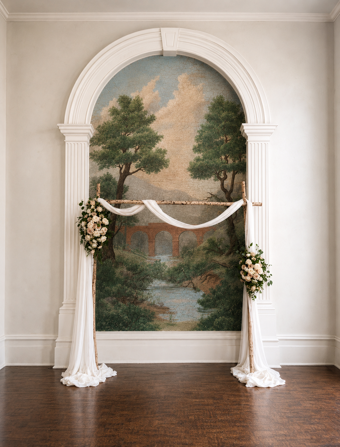 Indoor ceremony arch with white draping and soft floral accents